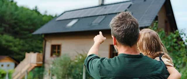 Mann zeigt Kind Photovoltaikanlage auf dem Dach