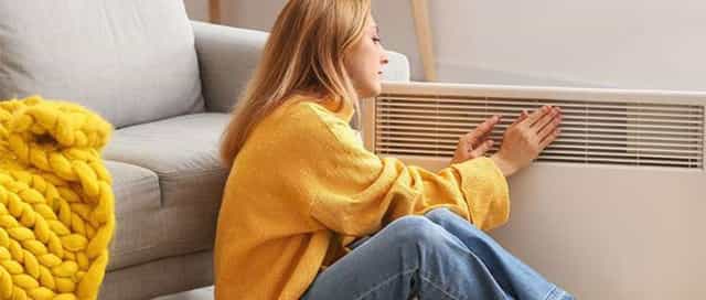 Frau sitzt vor Energie sparenden Heizung von Steinkühler in Leverkusen