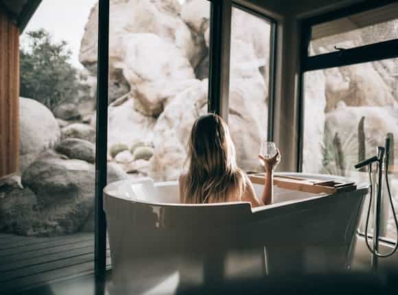 Frau mit einem Glas Wein in Badewanne von Steinkühler