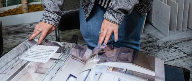 Eine Kundin plant ihr Traumbad anhand von Katalogen und Musterunterlagen und vergleicht verschiedene Gestaltungsmöglichkeiten; die Szene zeigt individuelle Planung, Inspiration und sorgfältige Auswahl moderner Badlösungen – Steinkühler Wasser & Wärme GmbH & Co. KG