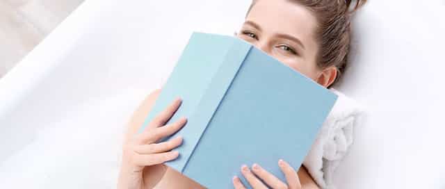 Frau liegt mit einem Buch über aktuelles in ihrer Badewanne von Steinkühler in Leverkusen.